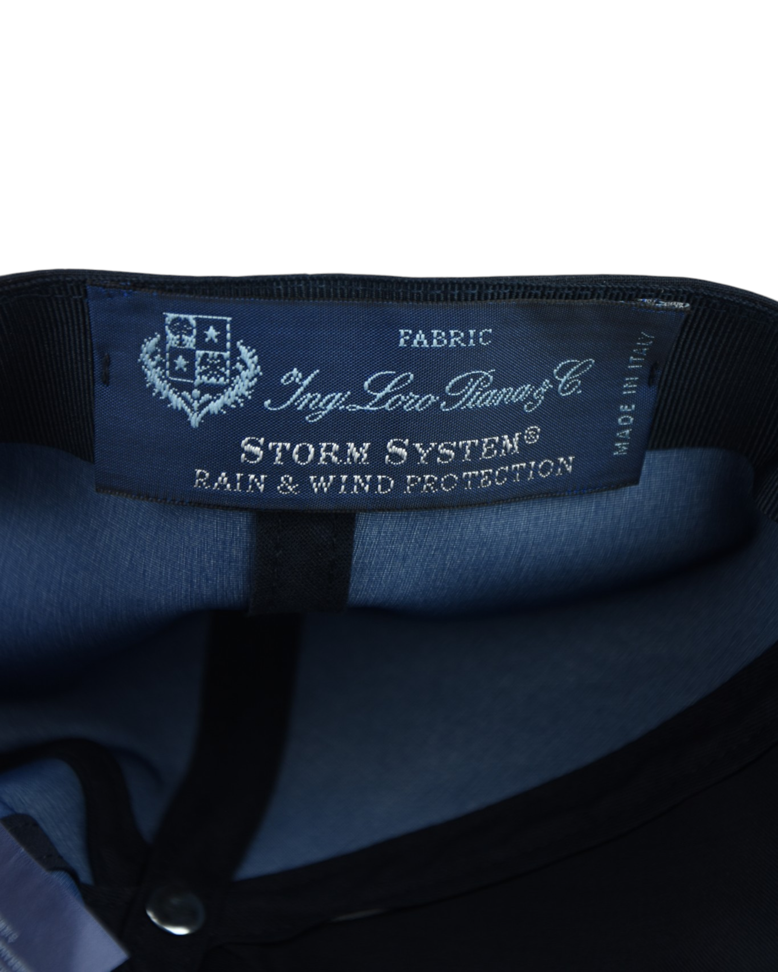 Storm System fabric label inside cap, shows FABRIC and BAIN & WIND PROTECTION