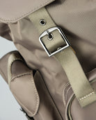 Beige adjustable shoulder strap with metal buckle and reinforced stitched patch.