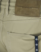 Beige pants waistband detail with interior label and stitched belt loops