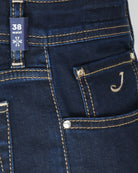 Dark wash denim jeans with waistband seam, coin pocket, and decorative J stitch