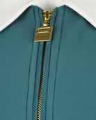 Fila track jacket zipper with gold hardware on teal fabric and white collar lining.