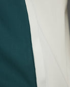 Fila track jacket side panel with teal fabric and white trim.