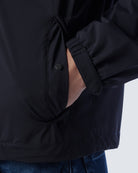 Navy jacket side with buttoned pocket flap and gathered storm panel
