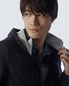 Navy hooded jacket close-up with front zipper, hood lining, and button strap