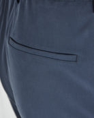 Navy silk-stretch pants close-up of side pocket opening and stitched trim