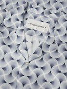 Close-up of short sleeve shirt fabric with swirling spiral print in navy and light blue