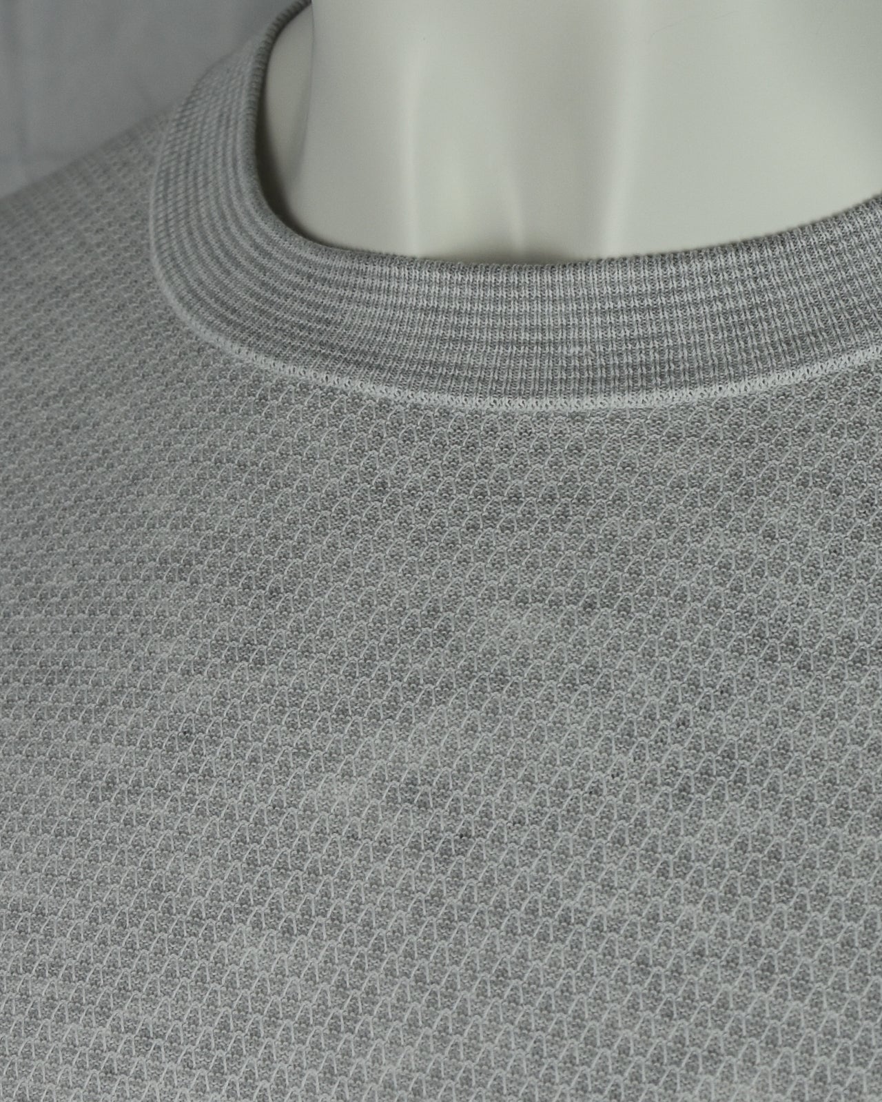 Grey textured knit T-shirt close-up of ribbed crew neckline