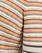 Striped knit polo sleeve and side seam; cream, orange, and gray horizontal stripes.