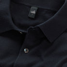 Deep navy polo collar with button placket, fabric texture, and small chest logo