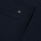 Dark knit lounge pants fabric close-up with waistband label and stitched seam