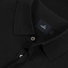 WAHTS black merino polo close-up of collar, placket buttons, and woven brand label