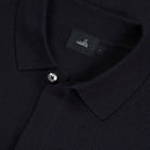 Close-up of dark blue merino cardigan collar, button front, and WAH... label