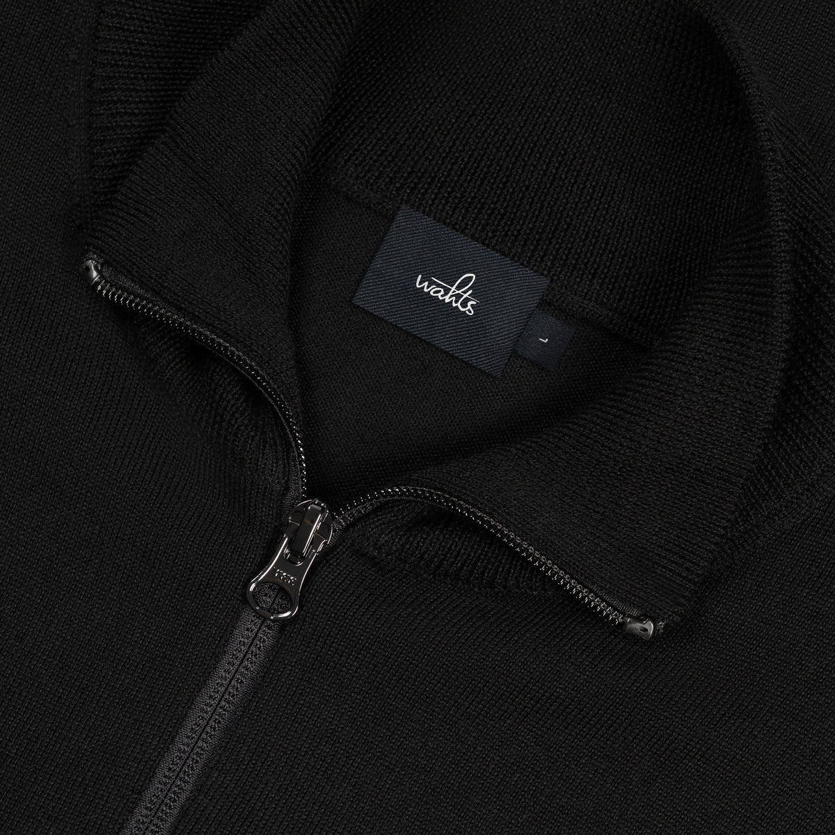 Black merino cardigan zipper and neck tag close-up