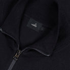 Close-up of dark merino cardigan zipper and WAHTS label at inner neck