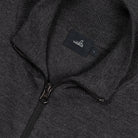 Merino cardigan close-up: WAHTS label, metal zipper, textured knit in dark melange