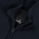 Full-zip cardigan close-up with branded zipper pull and ribbed knit cuffs