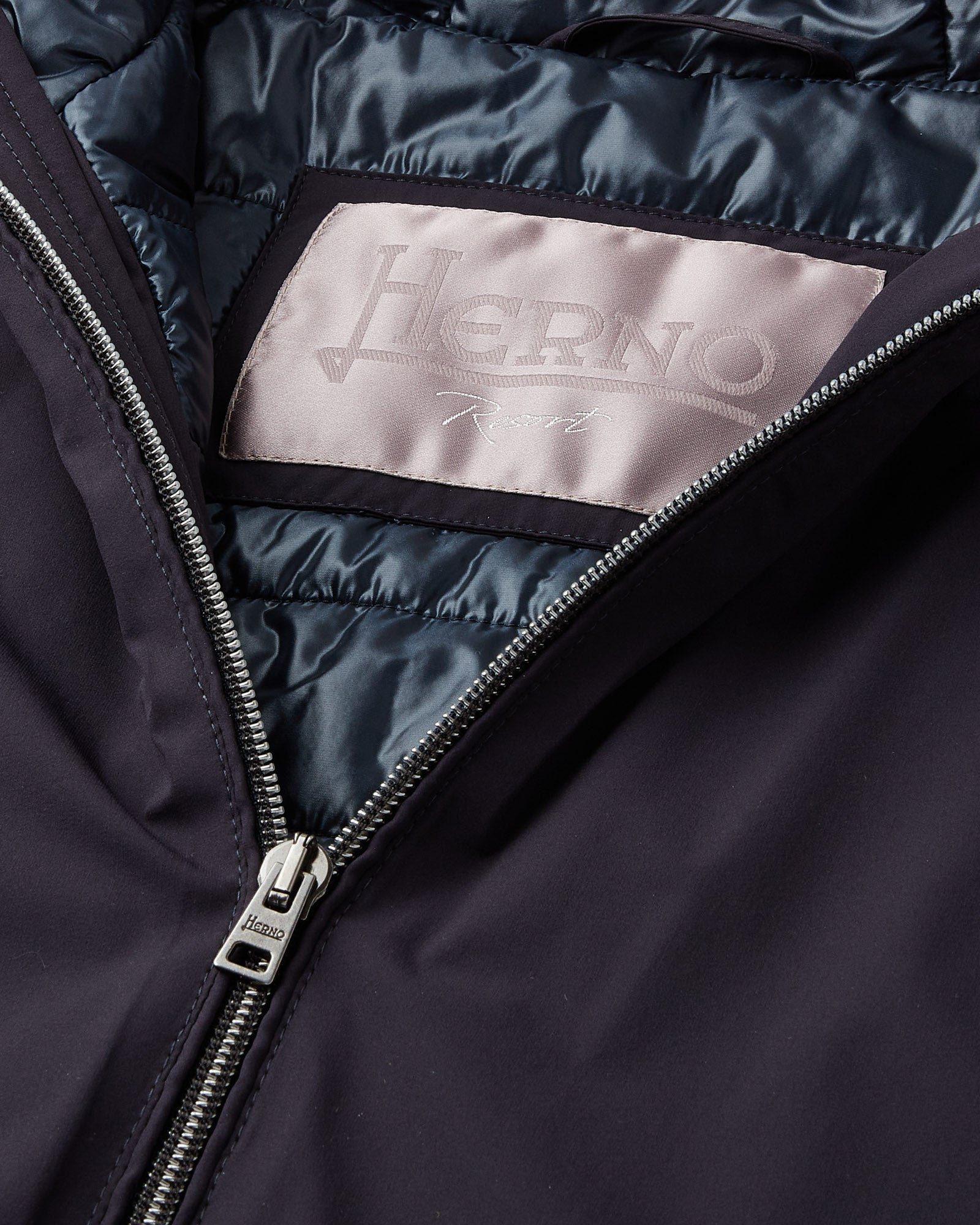 Herno zipper pull on navy hooded jacket, logo patch on satin lining