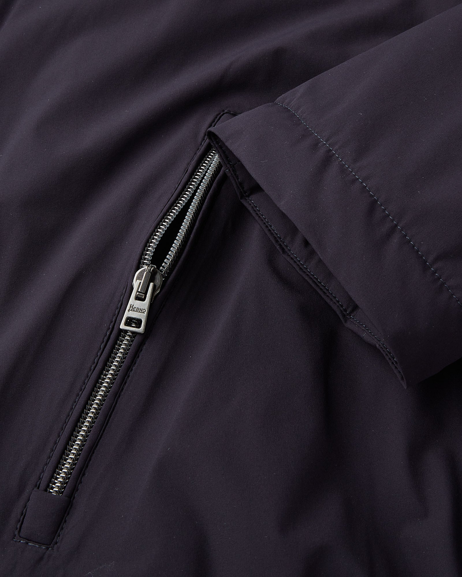 Navy packable jacket sleeve, angled zip pocket with metal zipper pull