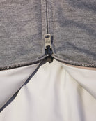 Reversible bomber jacket zipper with black pull and white interior lining at opening