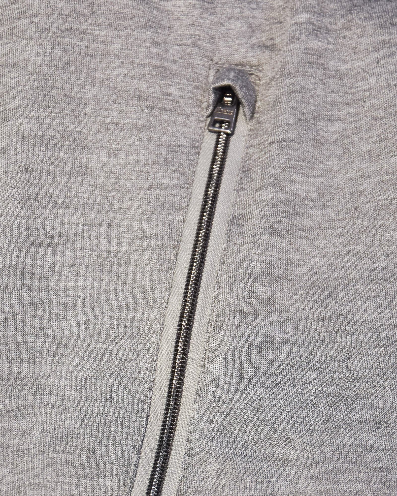 Reversible bomber jacket close-up of heather gray front with metal zipper and pull tab