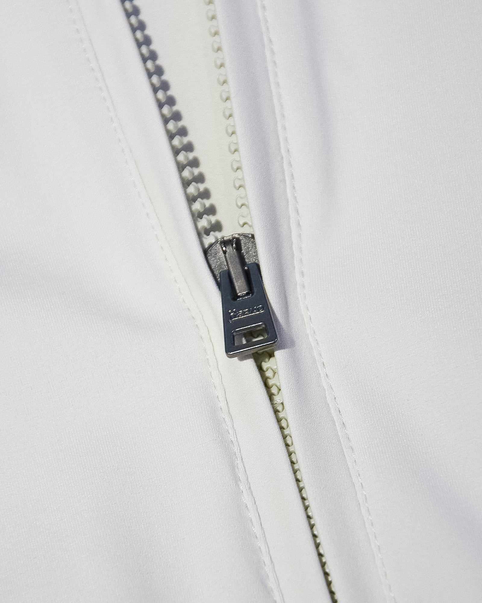 Off-white nylon jacket front zipper with dark pull and metal slider