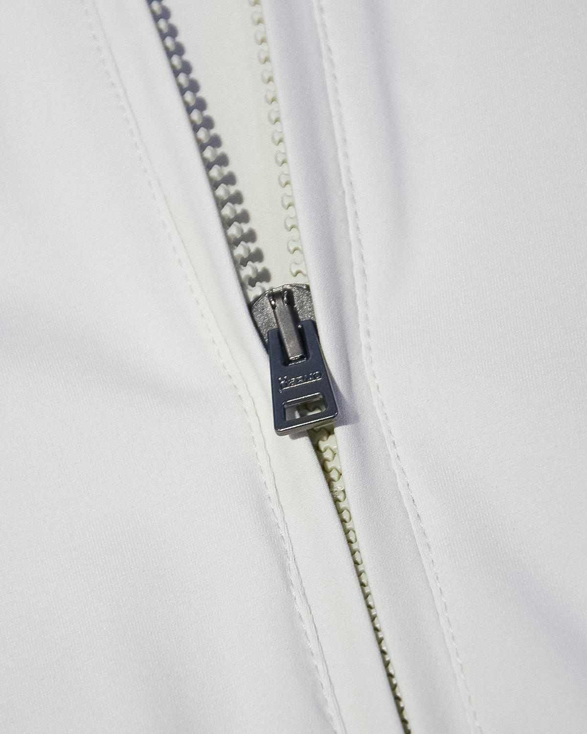 Front zipper detail with dark pull on off-white nylon bomber jacket