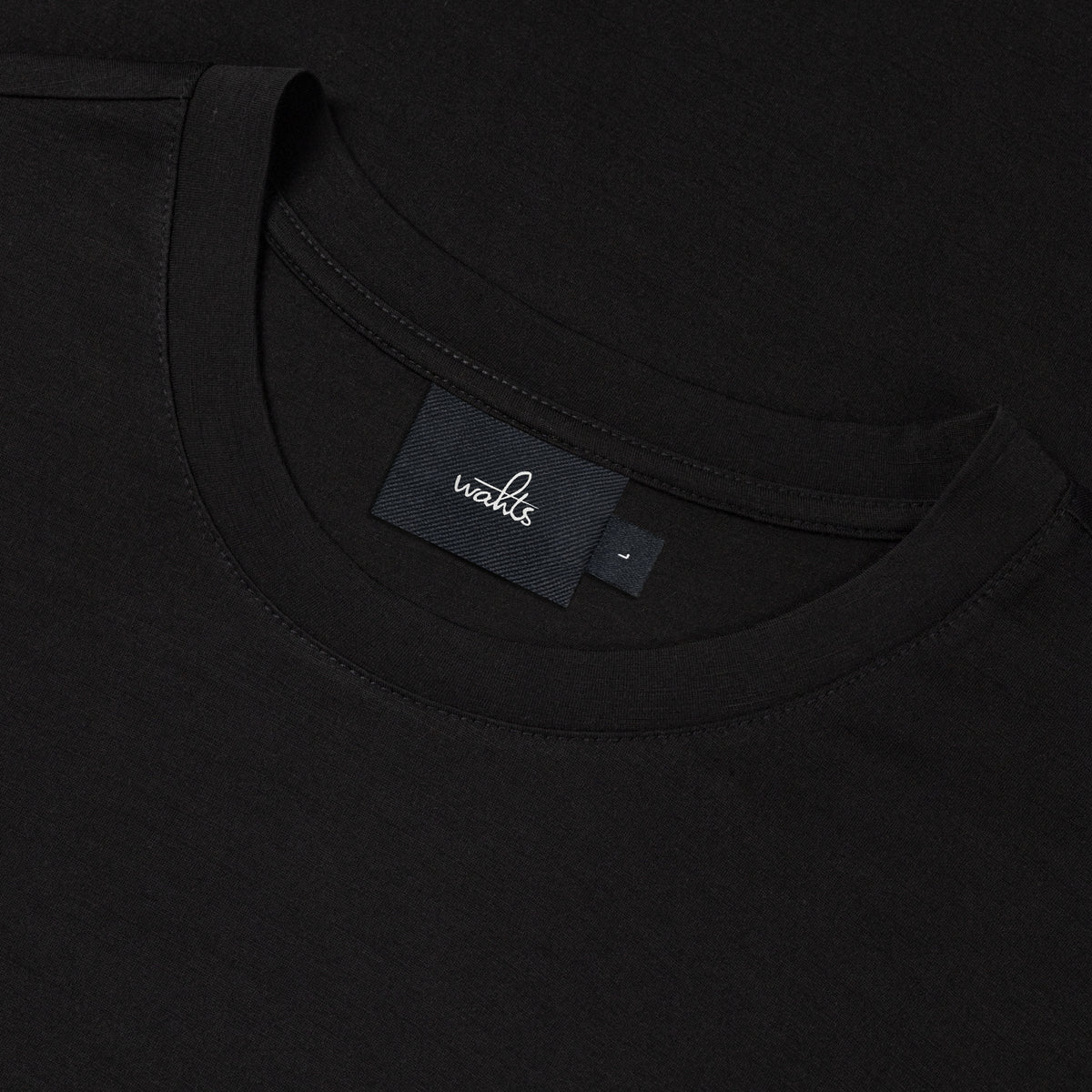 Black jersey T-shirt neckline with WAHTS logo label