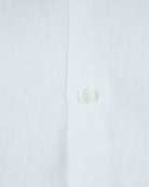 White linen shirt button close-up with fabric texture
