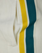 Side stripe detail on cream velour shorts, yellow and teal