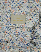 Paul & Shark swim shorts fabric close-up, blue and beige diamond geometric print, logo patch