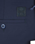 Navy chino shorts detail: front button, stitched pocket, brand patch