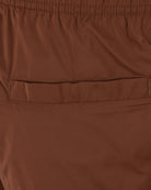 Close-up of brown swimshorts front pocket and stitched hem seam