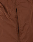 Close-up of brown swimshorts center seam with vertical stitching and paneling