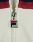 Silver zipper pull with F-style logo tag on cream track jacket.