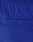 Cobalt blue swim shorts fabric close-up with elastic waistband and stitched hem
