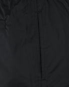 Black swim shorts close-up of vertical seam and side panel stitching