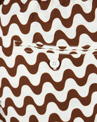 Swim shorts waistband close-up with brown-and-ecru wavy print and drawcord