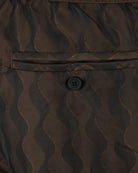 Swim shorts waist close-up with elastic band and small button under flap