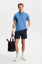 Navy athletic shorts on model with elastic waistband and small side logo