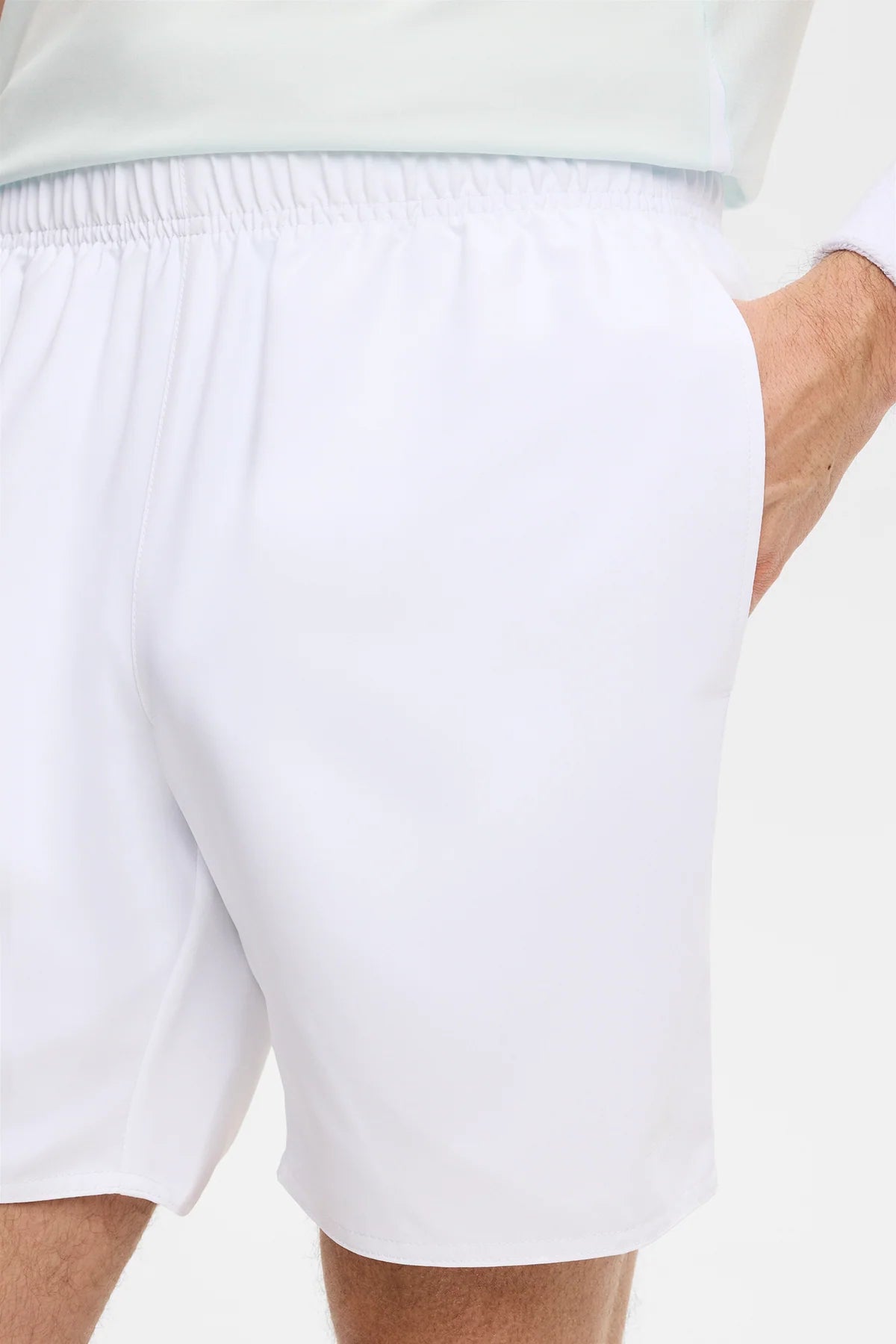White shorts back view close-up with elastic waistband and curved side hem.