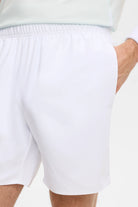White shorts back view close-up with elastic waistband and curved side hem.