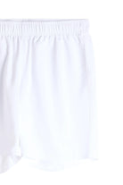 White shorts close-up: elastic waistband with gathered fabric and straight hem.