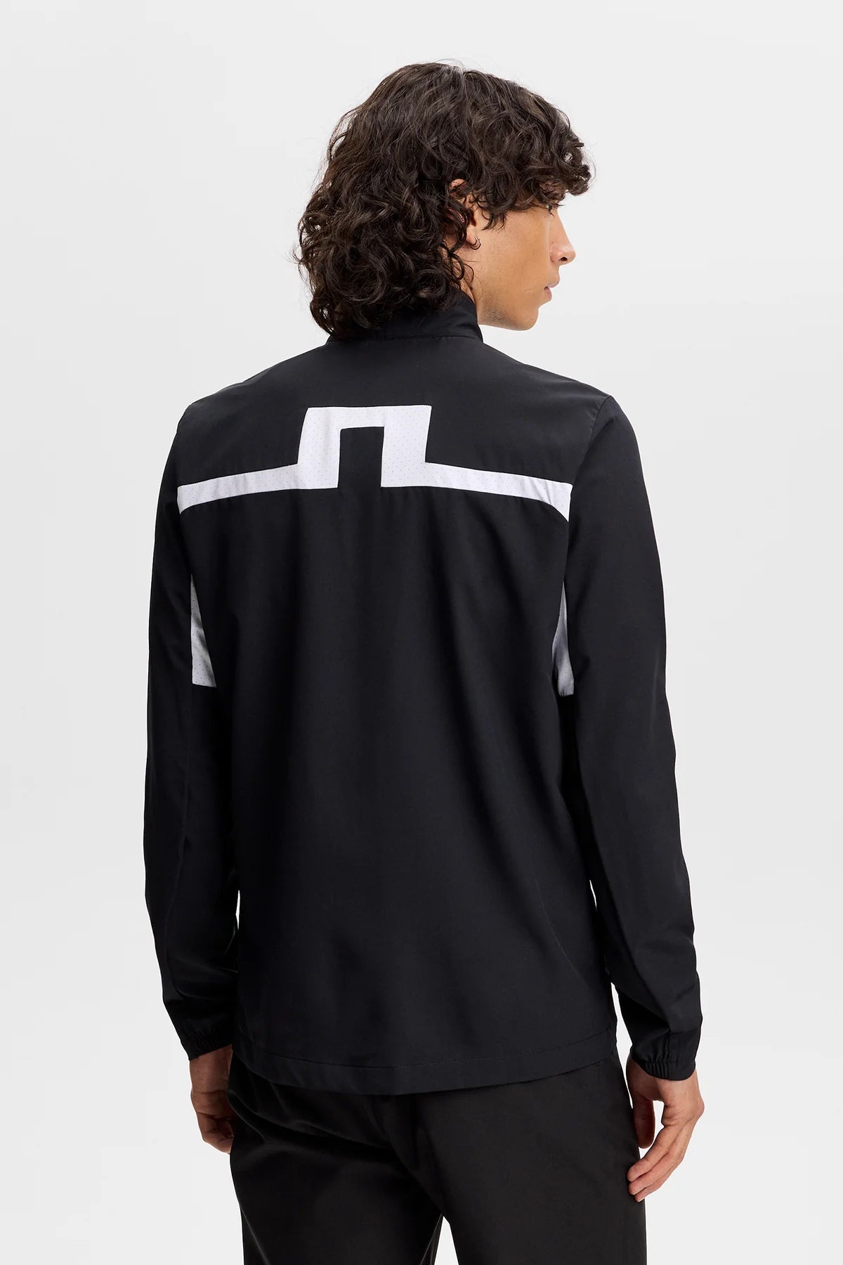 Black jacket back view with centered white stripe graphic on upper back.