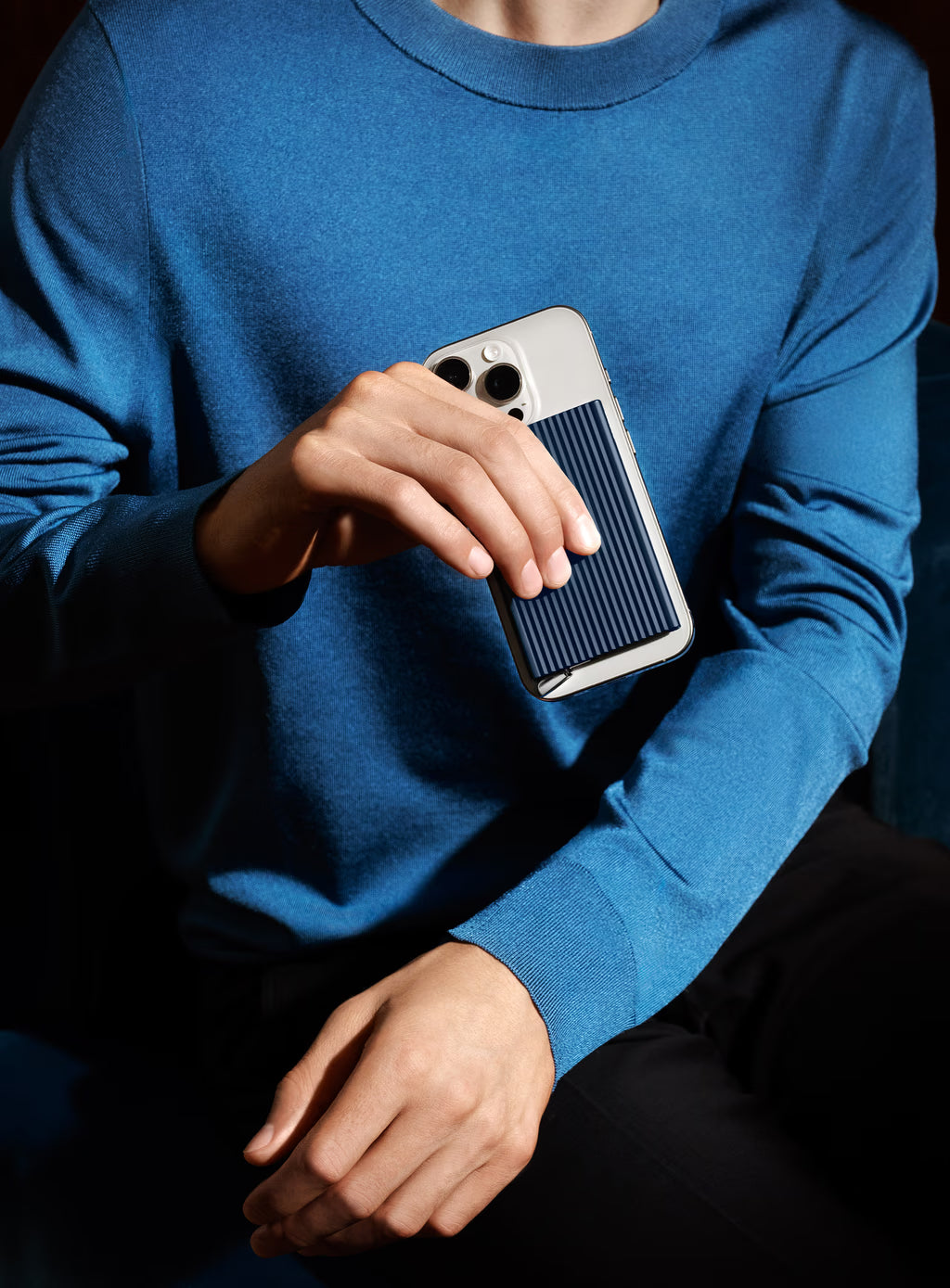 Navy fluted card protector held with smartphone in hand