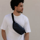 Midnight blue waterproof crossbody bag worn diagonally with adjustable strap