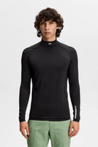 Black compression long-sleeve mock-neck top with sleeve logo detail and fitted hem.
