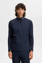 Navy full-zip vest with stand collar, model wearing over long-sleeve top