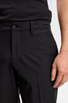 Black waistband detail with button, belt loops, and side pocket opening