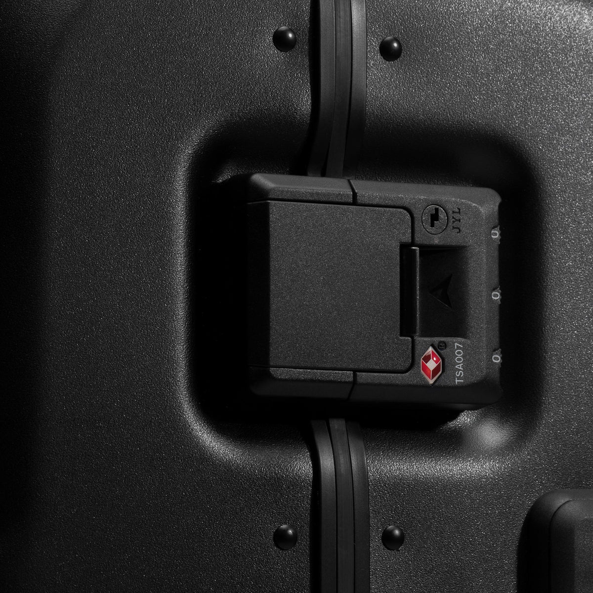 Black hardshell suitcase side lock compartment detail with access panel