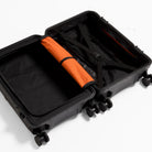 Black hardshell cabin suitcase, open with interior divider and orange compression strap